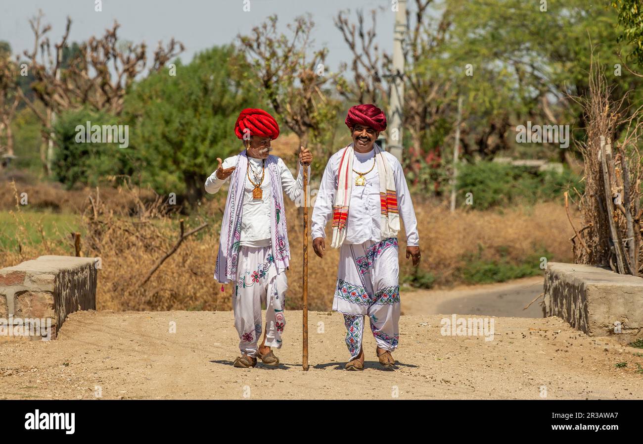 Two men of the Rabari ethnic group in national dress are walking along the road. Stock Photo