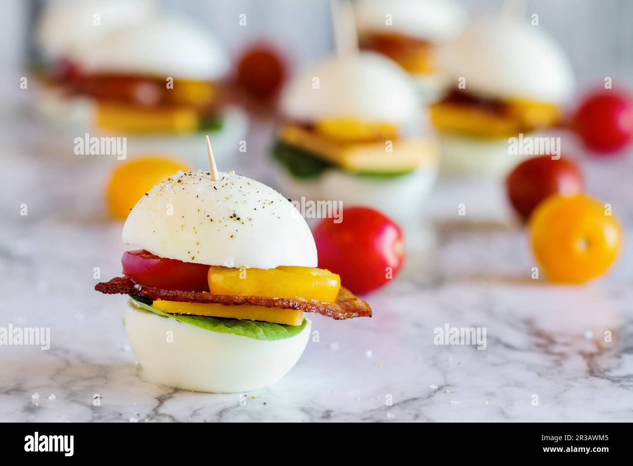 Keto BLT egg sandwich, or egg bun - Boiled eggs with spinach, turkey bacon, cheddar cheese and tomatoes Stock Photo