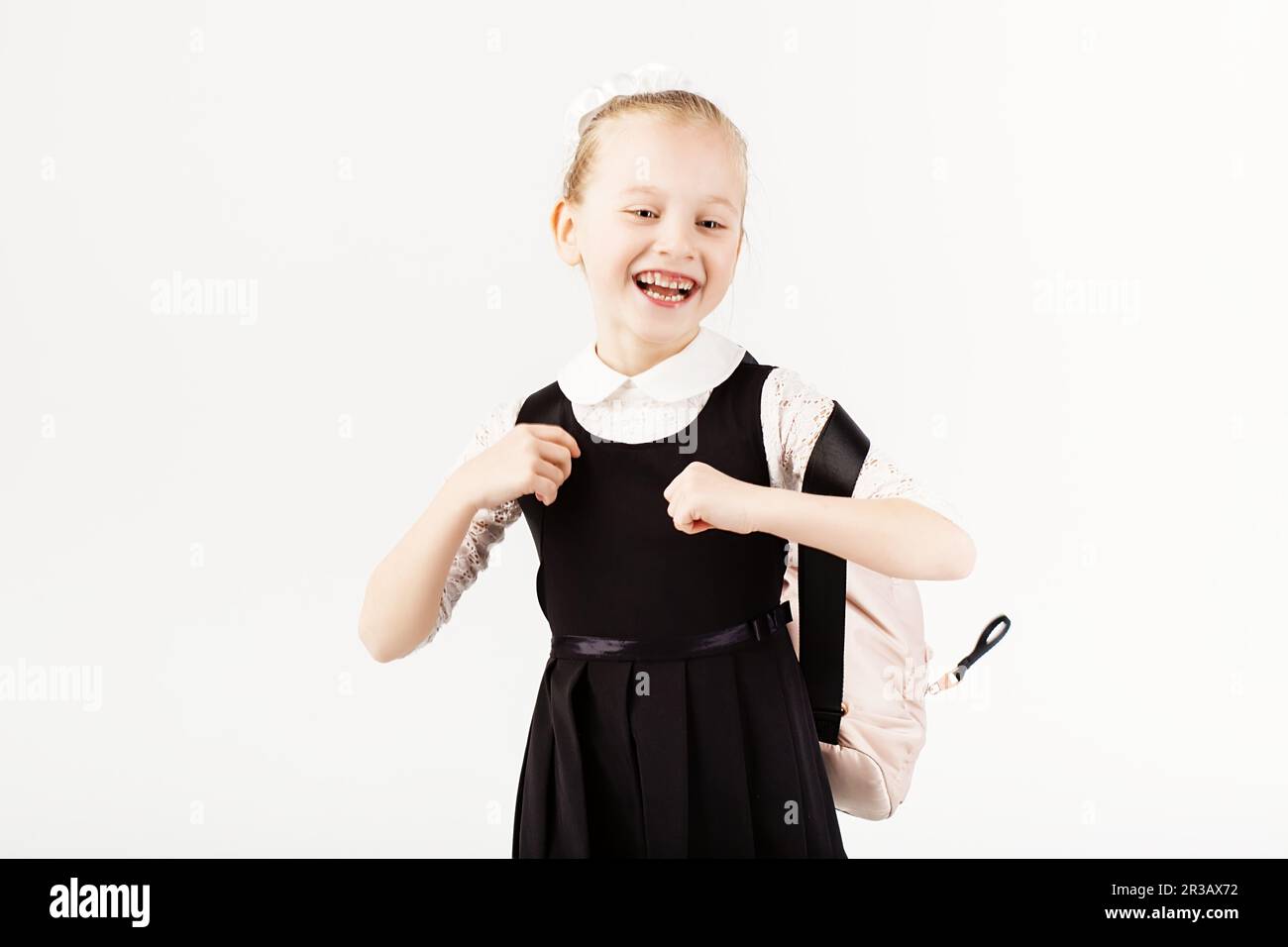 Funny smiling little girl with big backpack jumping and having fun
