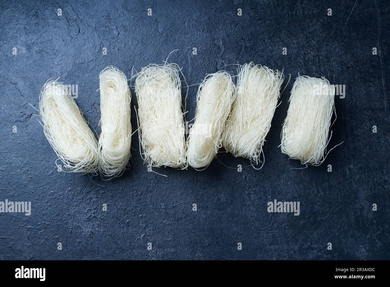 Uncooked rice noodles rolled in nests Stock Photo