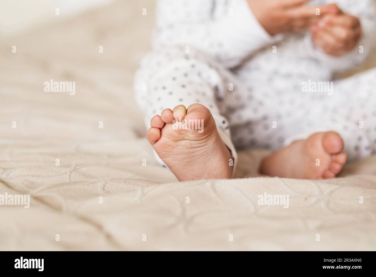 A close-up of tiny baby feet. Newborn Baby legs on the bed Stock Photo