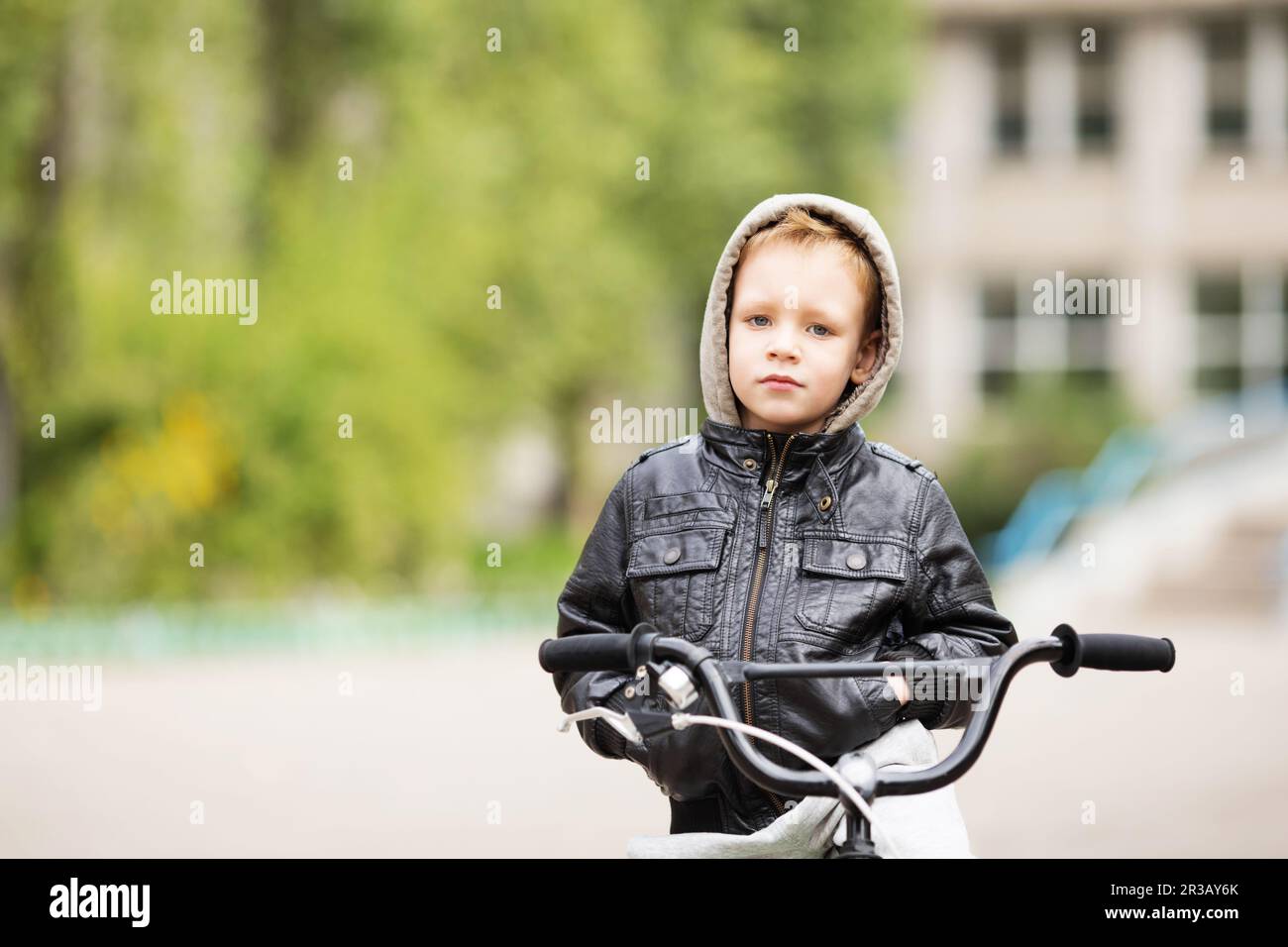 Portrait of adorable little urban boy wearing black leather jacket. City style. Urban kids. The boy Stock Photo
