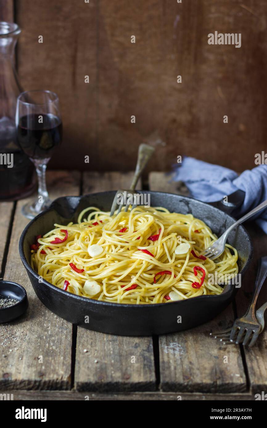 Spaghetti aglio, olio e peperoncino, blach pepper, red wine (Italy) Stock Photo