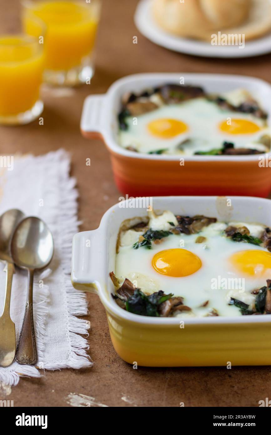 Mushroom, spinach and egg bake, orange juice, bread roll Stock Photo