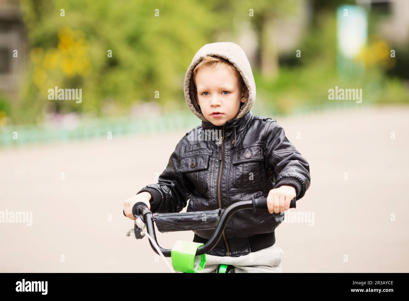 Portrait of adorable little urban boy wearing black leather jacket. City style. Urban kids. The boy Stock Photo