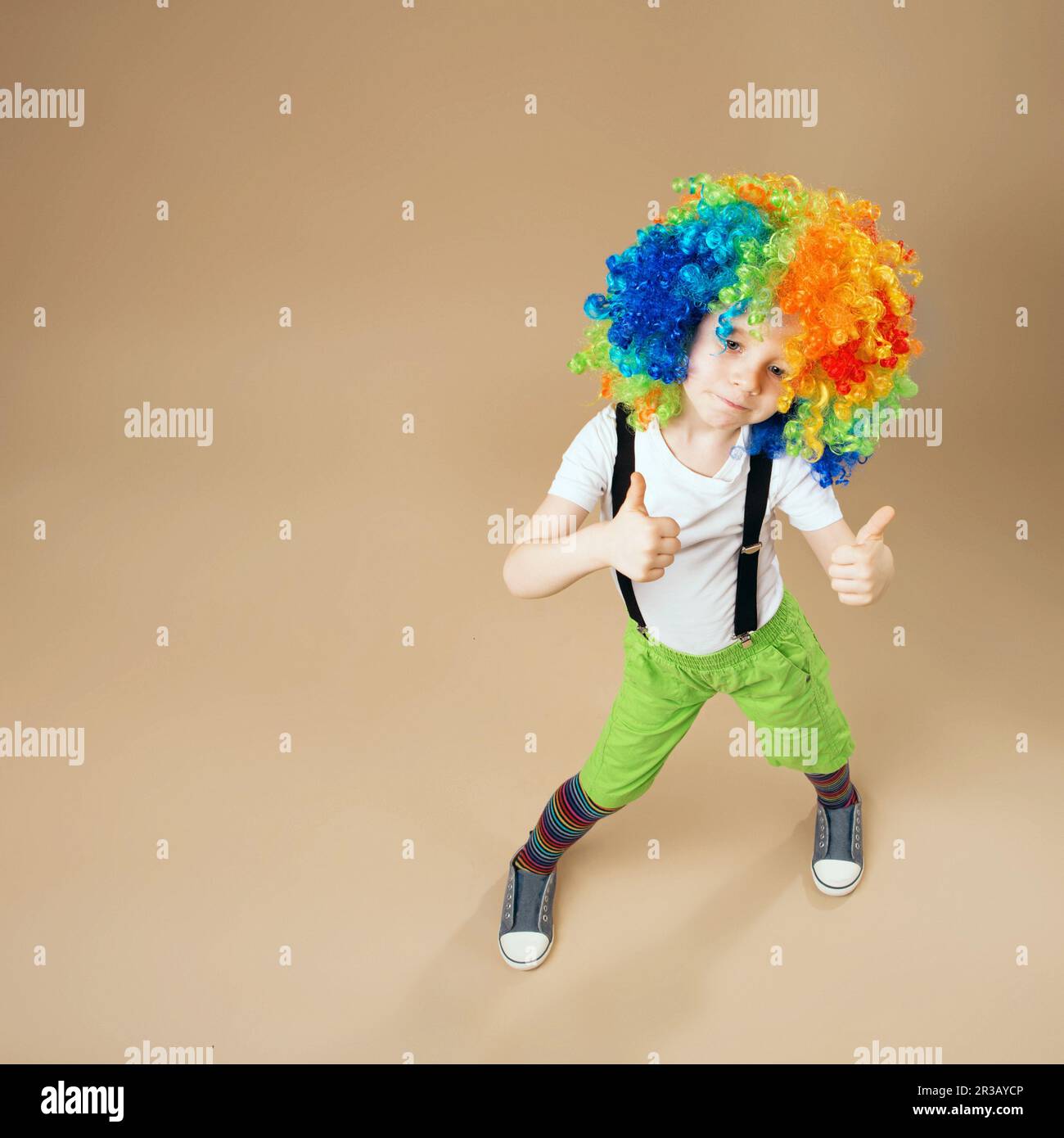 Blithesome children. Happy clown boy with large colorful wig. Little ...