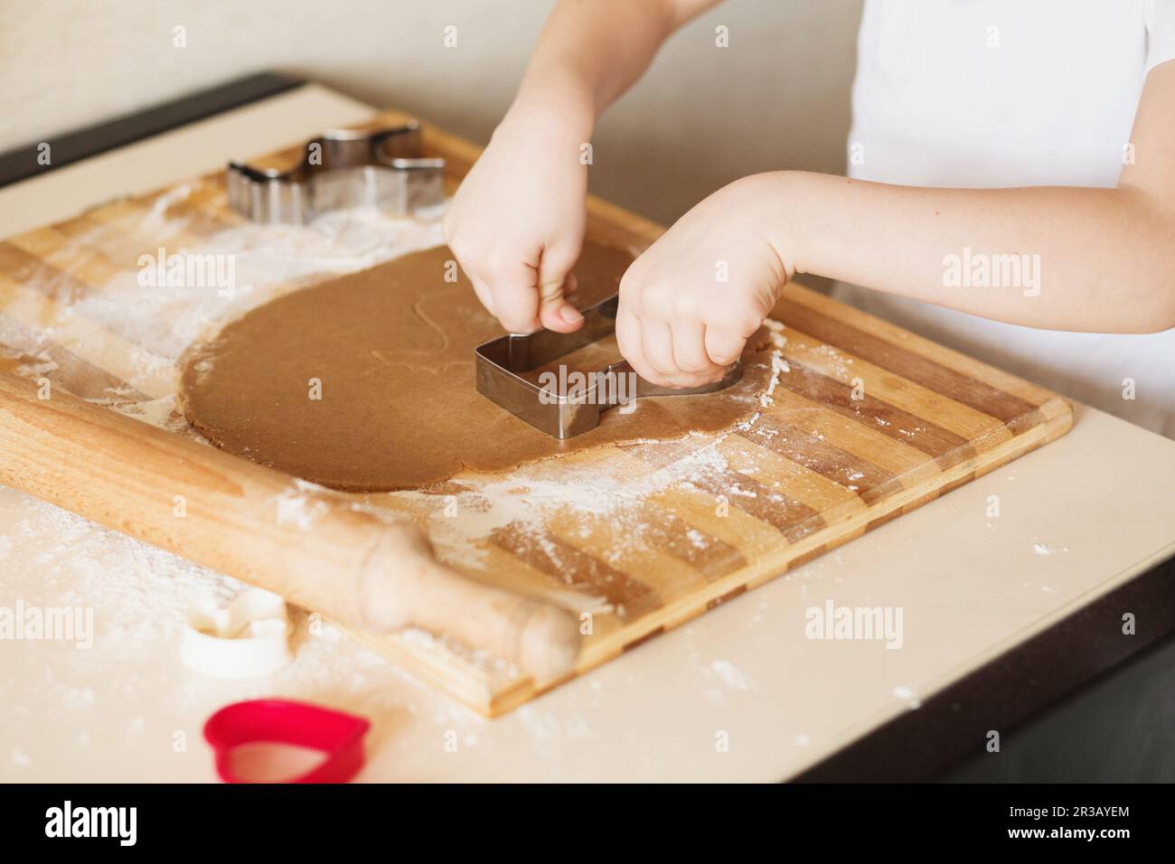 Master class for children on baking christmas cookies. Young children learn to cook a honey-cake. Ki Stock Photo