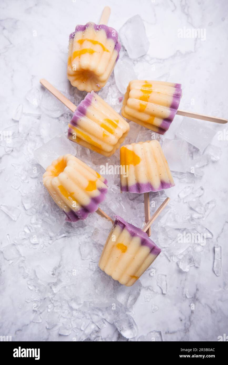 Frozen soya yoghurt on sticks with blueberries, vanilla and mango Stock