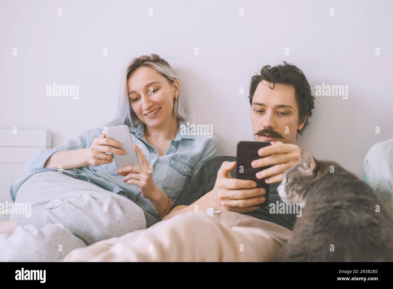 Happy couple using smart phone at home Stock Photo