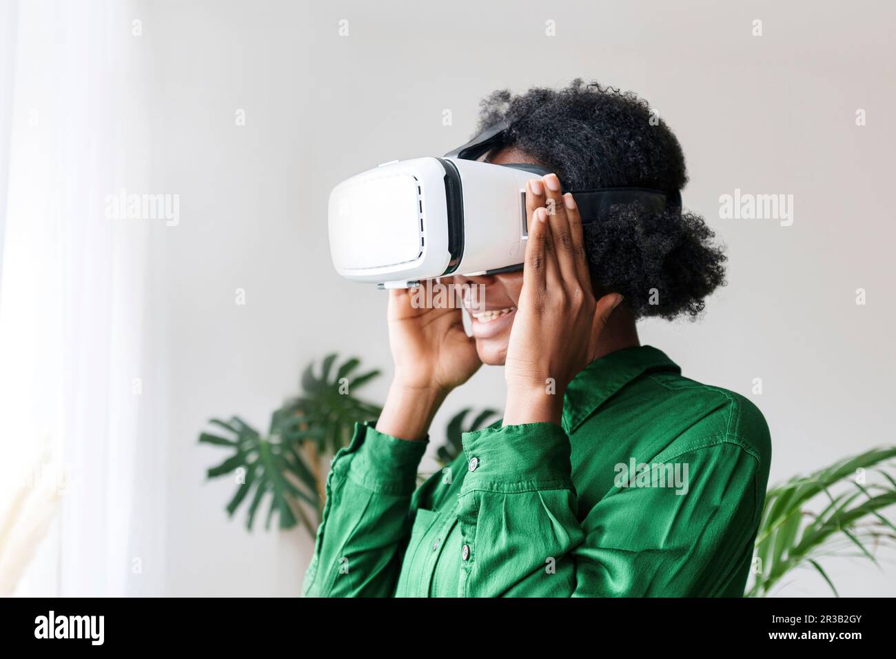 Smiling woman wearing virtual reality simulator Stock Photo