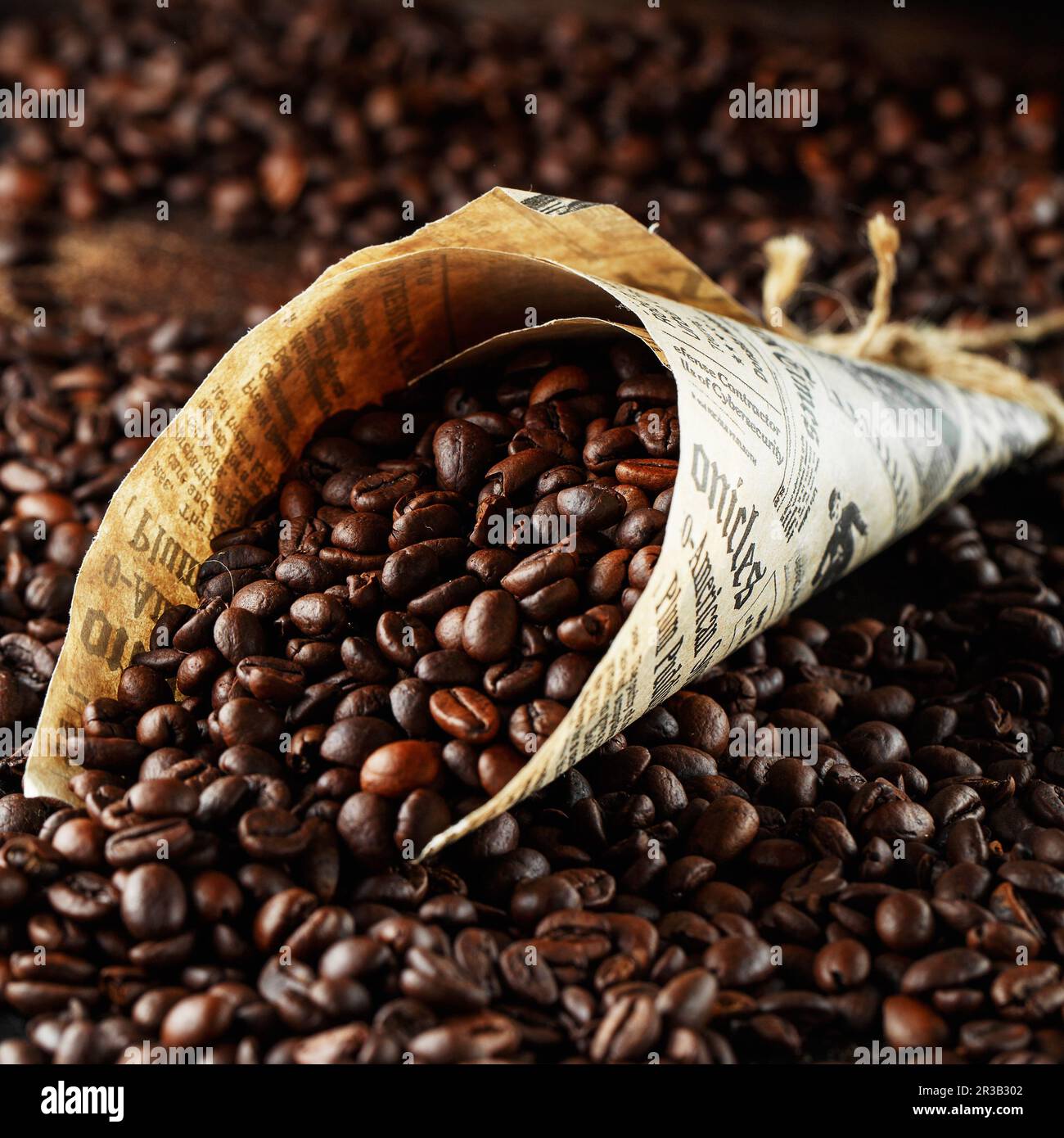 Black coffee beans studio shot. Freshly roasted coffee beans in a cone of paper Stock Photo