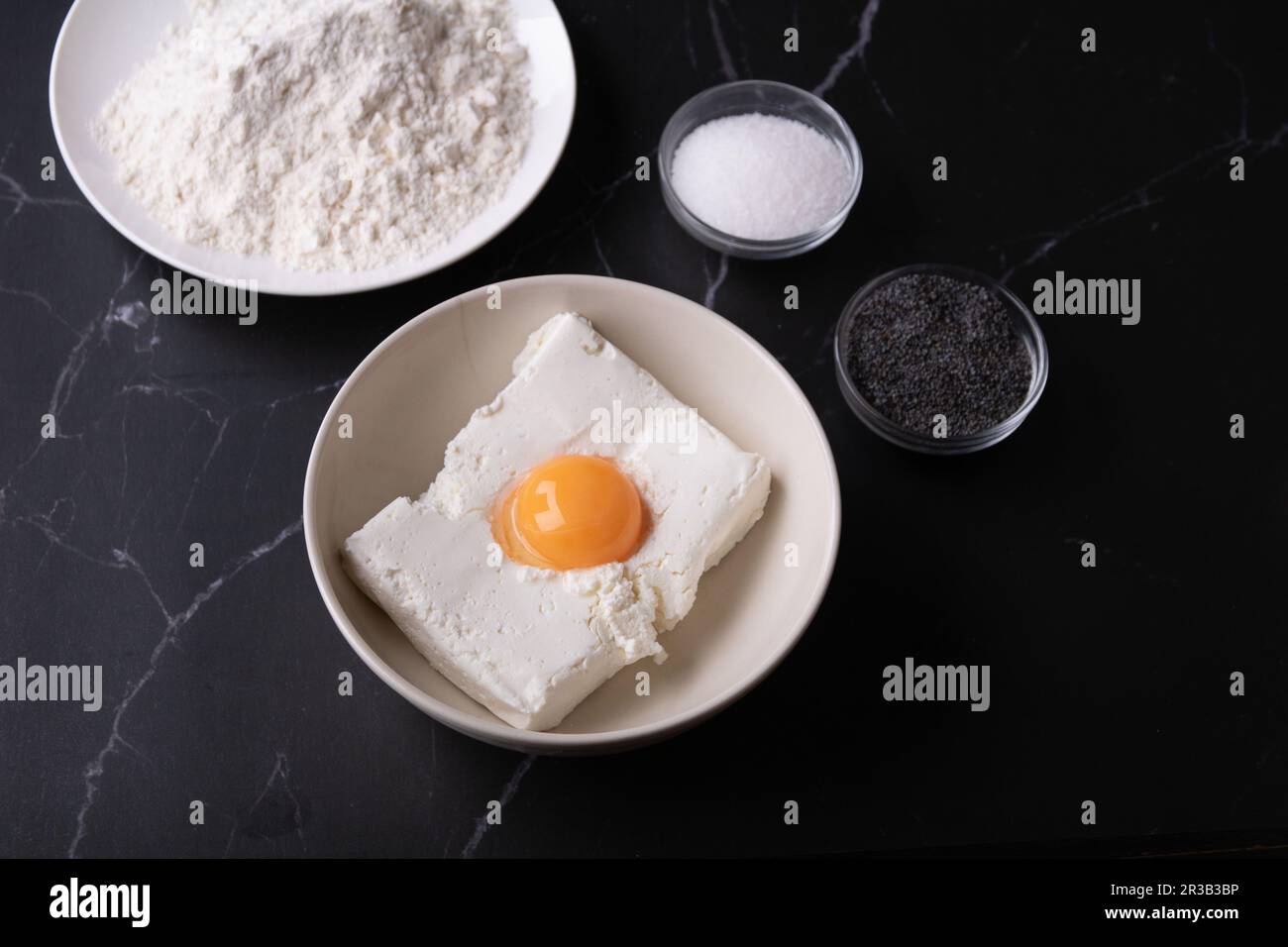photo yolk from an egg, sugar, cottage cheese, poppy seed on a dark background Stock Photo