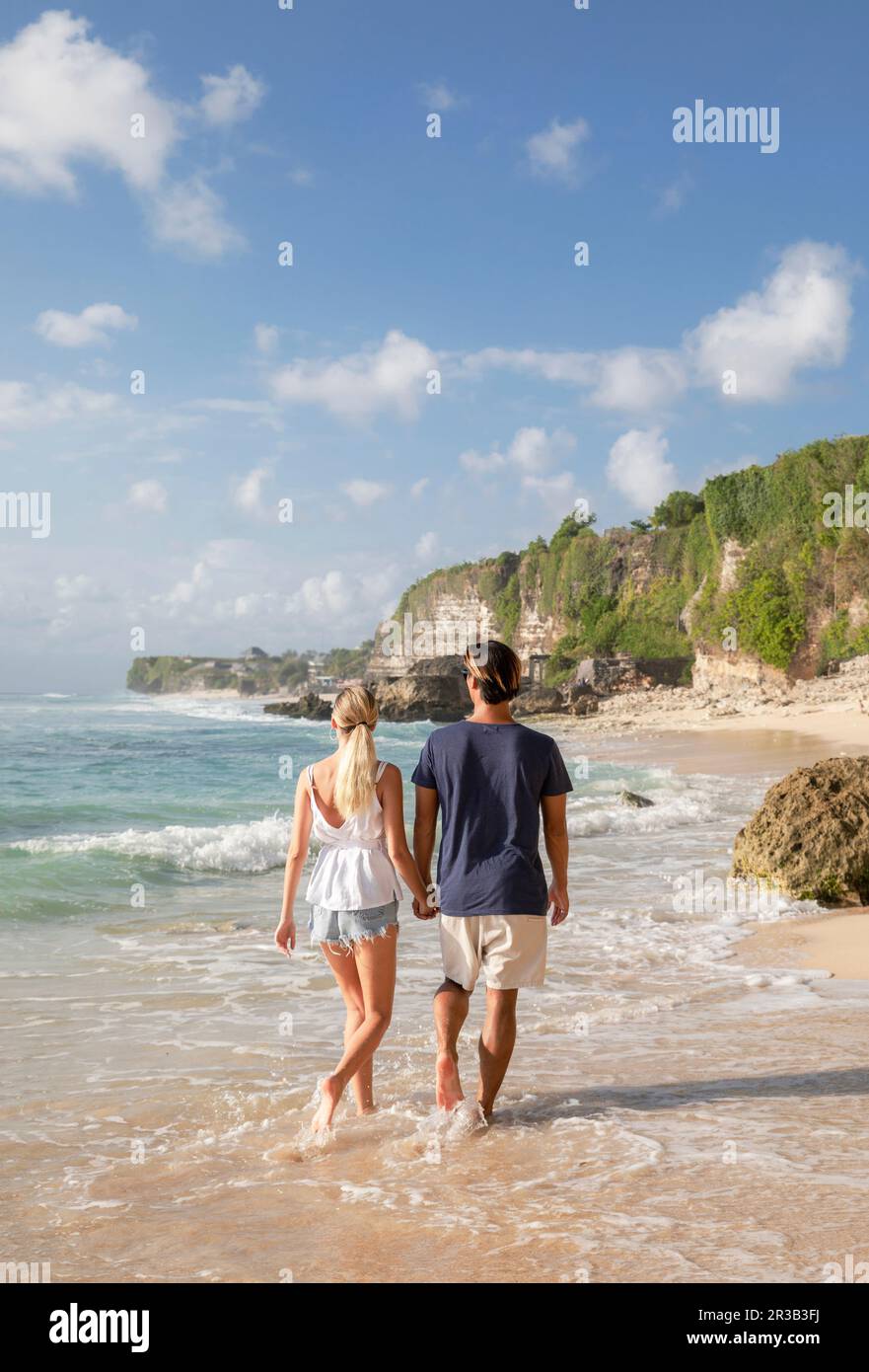 Couple holding hands and walking at beach Stock Photo