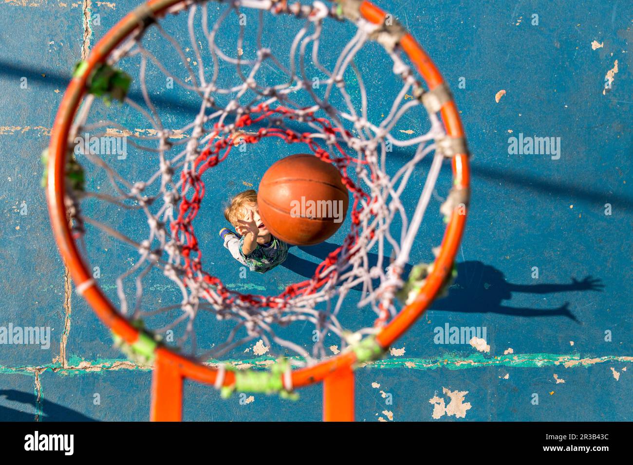 Son throwing basketball standing under hoop Stock Photo Alamy