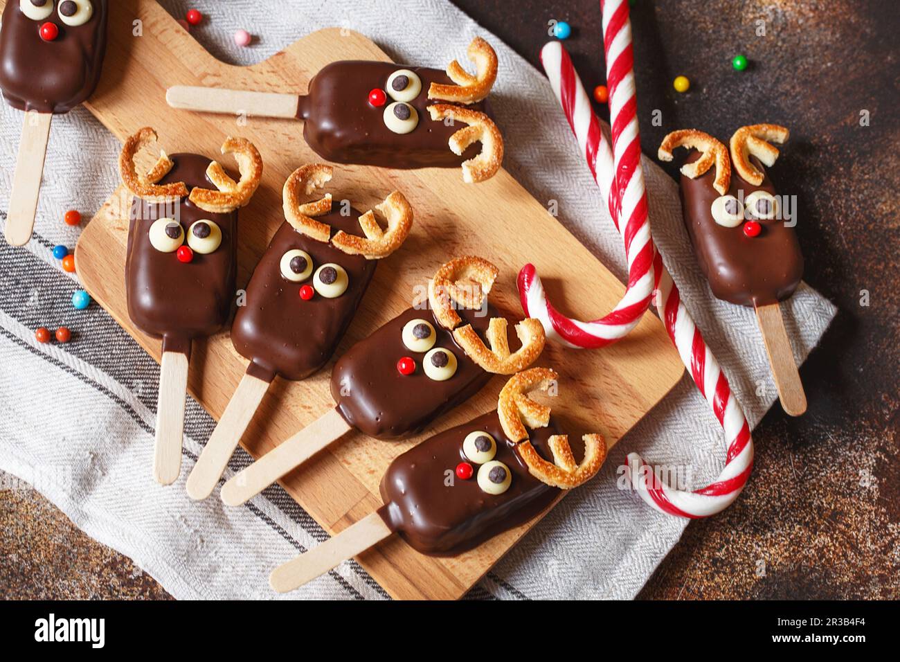 Chocolate popsicle. Christmas concept. Chocolate ice cream on a stick with a Christmas deer face wit Stock Photo