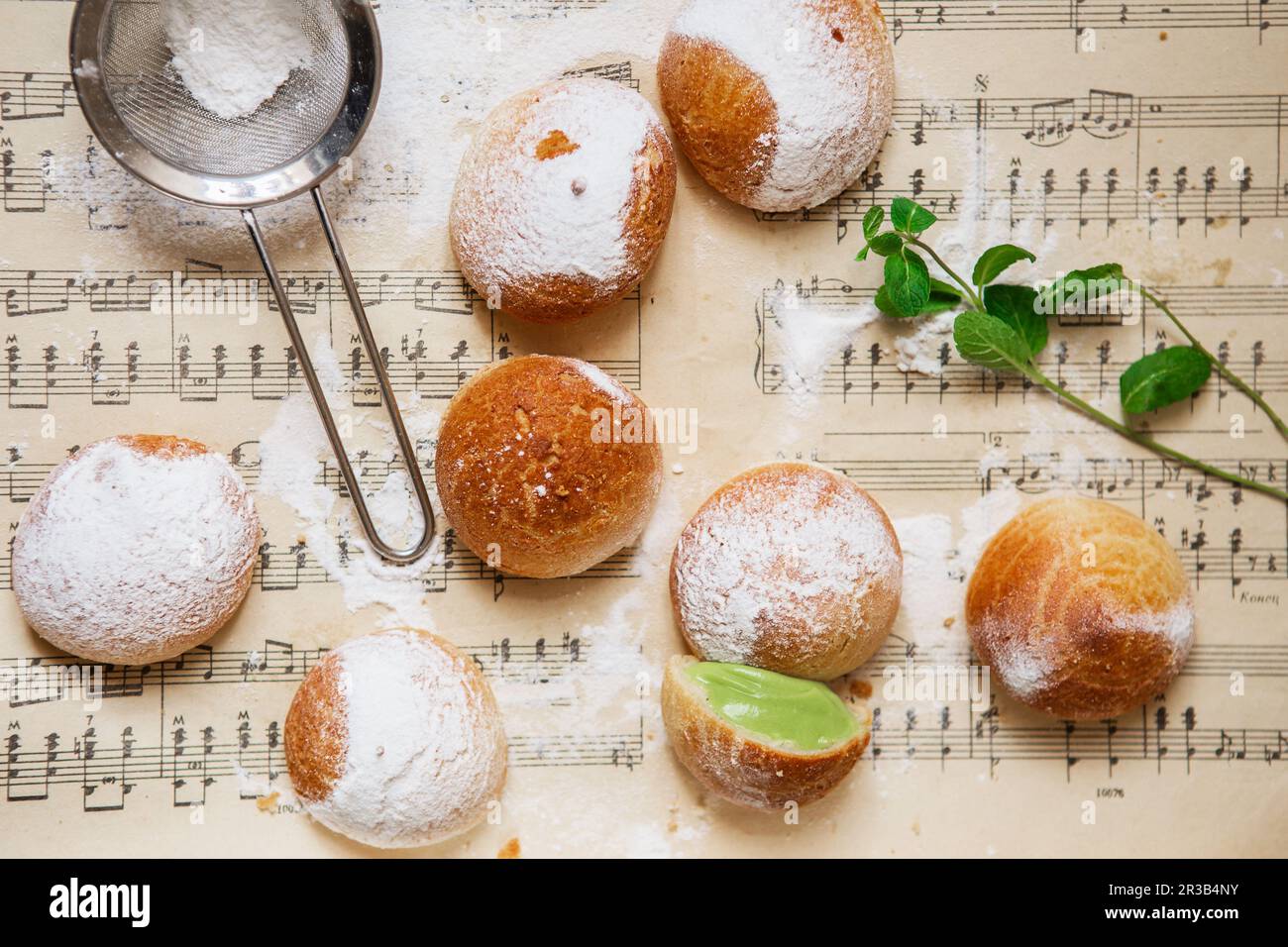 Homemade profiteroles on the music sheet with notes. Profiteroles (choux Ã  la crÃ¨me) - French choux Stock Photo