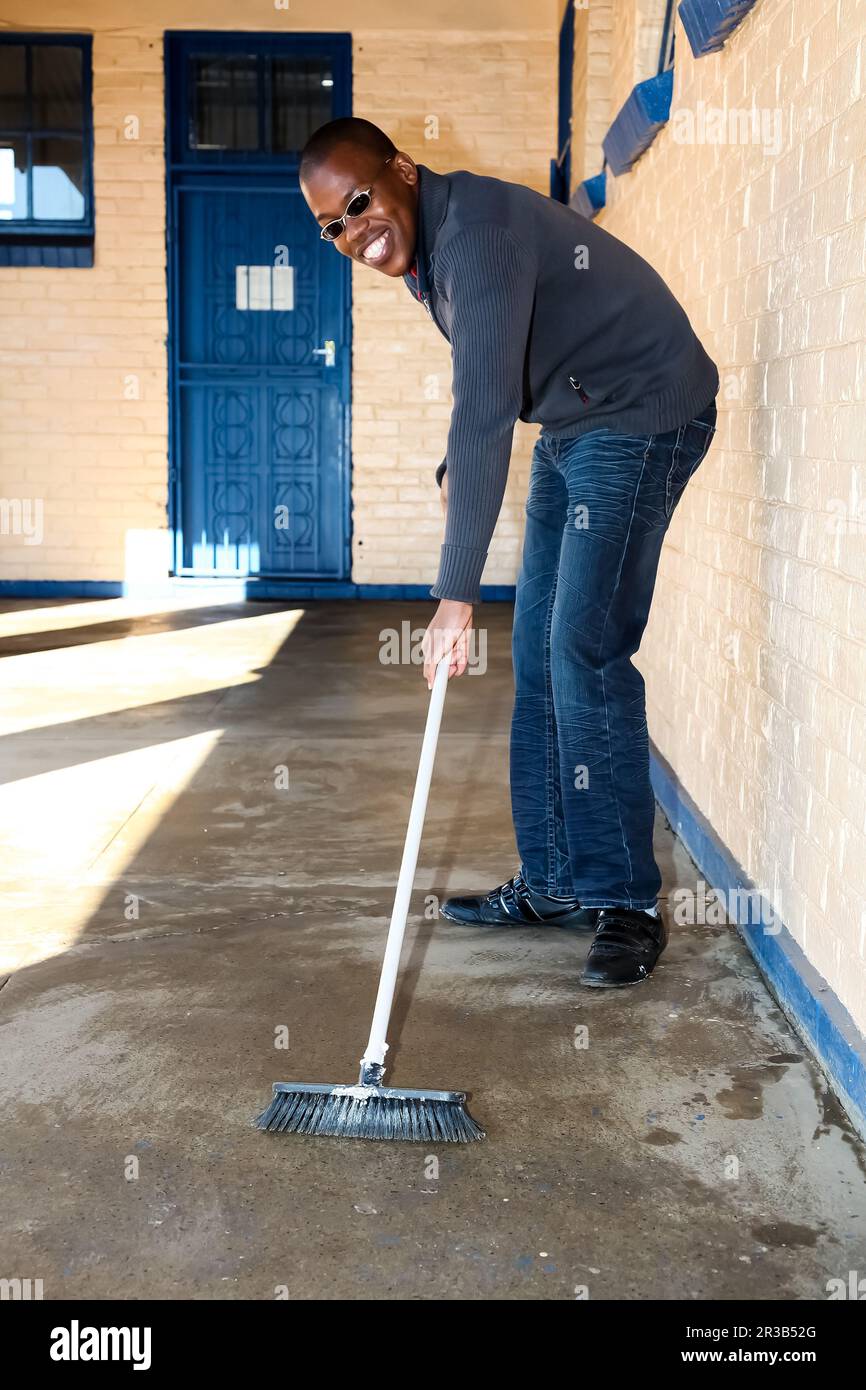 African man performing community service volunteer cleaning work at