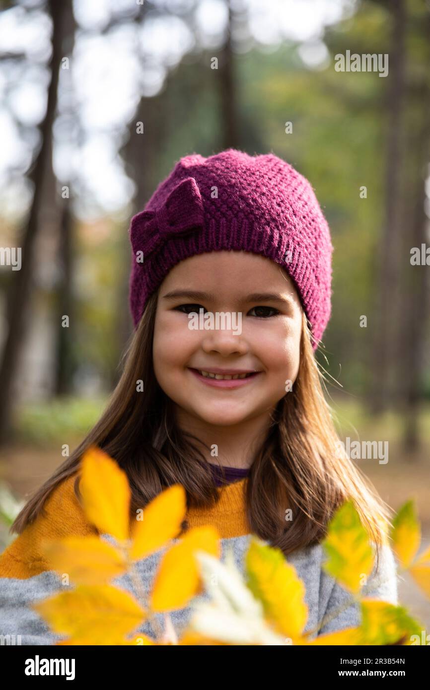 Happy girl with knit hat and autumn leaves Stock Photo