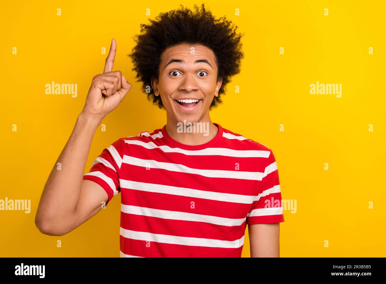 Photo of shocked smart man dressed red t-shirt pointing finger up isolated yellow color background Stock Photo