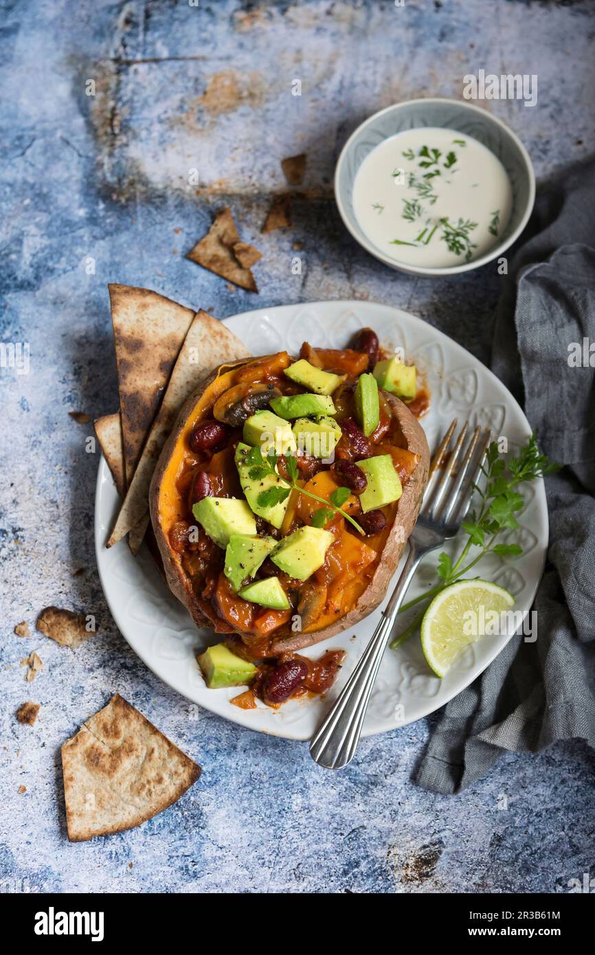 Jacket sweet potato filled with vegan chilli Stock Photo Alamy
