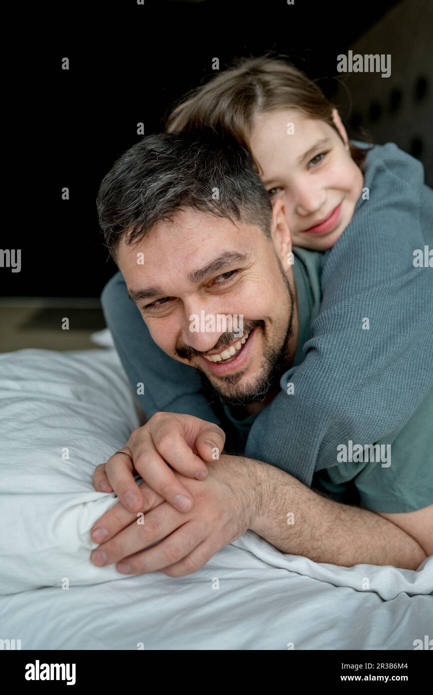 Father spending leisure time with son on bed Stock Photo