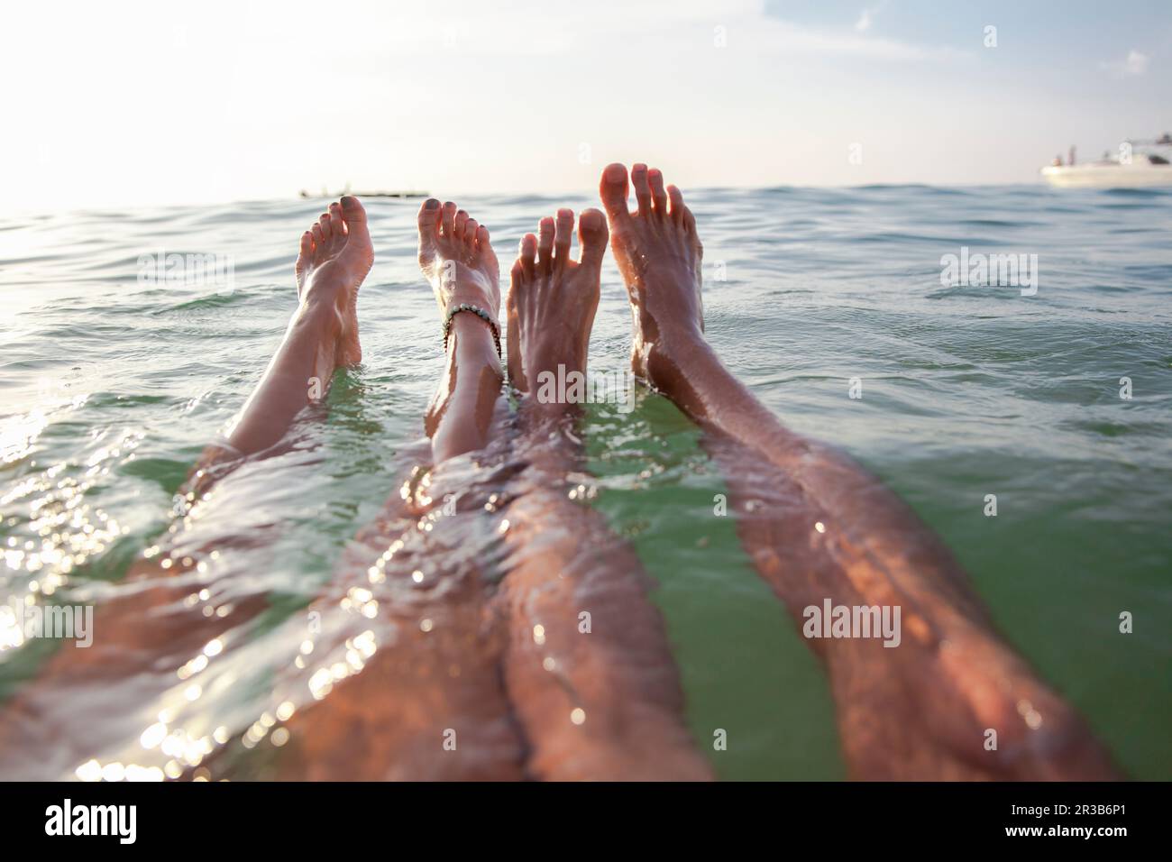 Legs of couple floating in sea Stock Photo