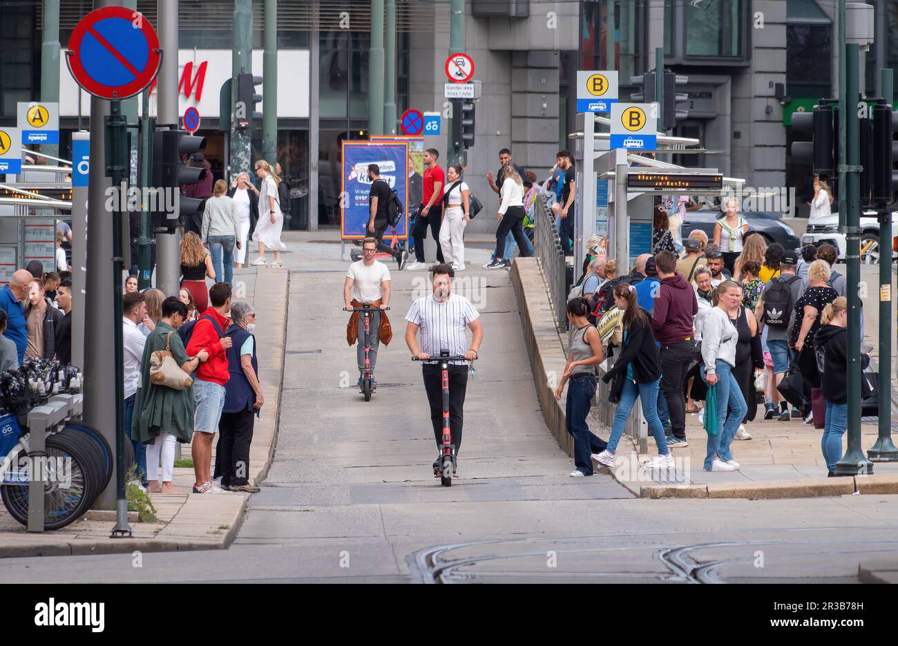 Electric rental scooters passing through a bus stop at
