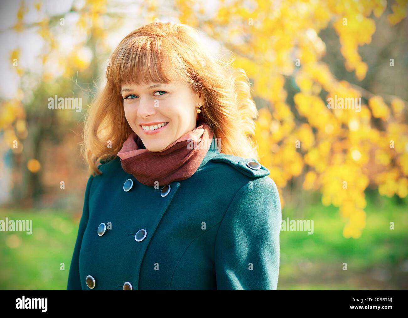 Portrait of smiling happy urban girl walking in city autumn park Stock Photo