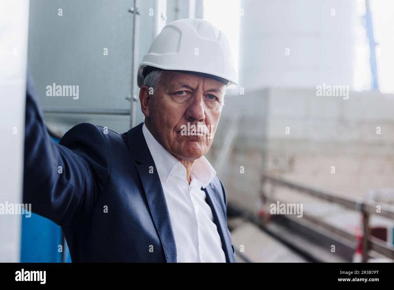 Senior businessman wearing hard hat in factory Stock Photo