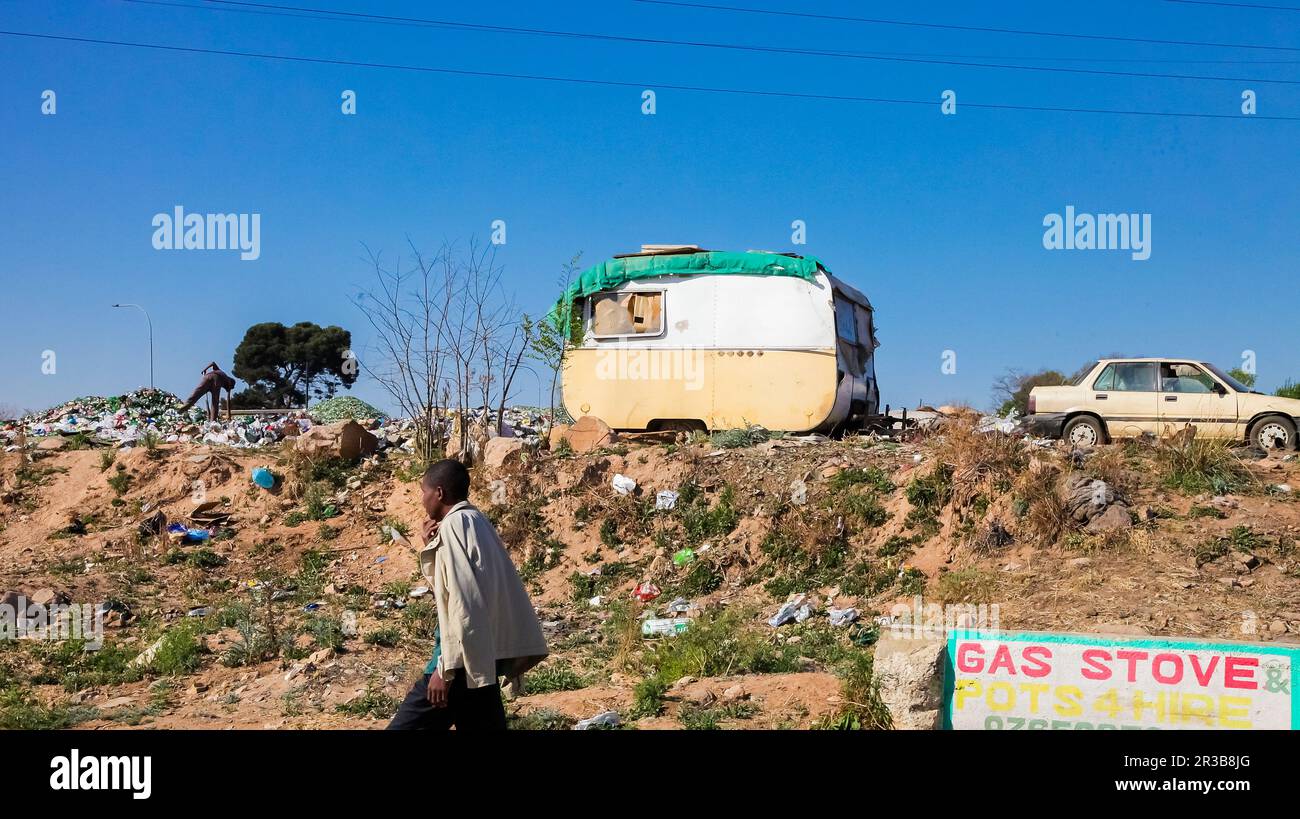 Recycling Garbage Picker sorting glass bottles in urban Soweto South Africa Stock Photo