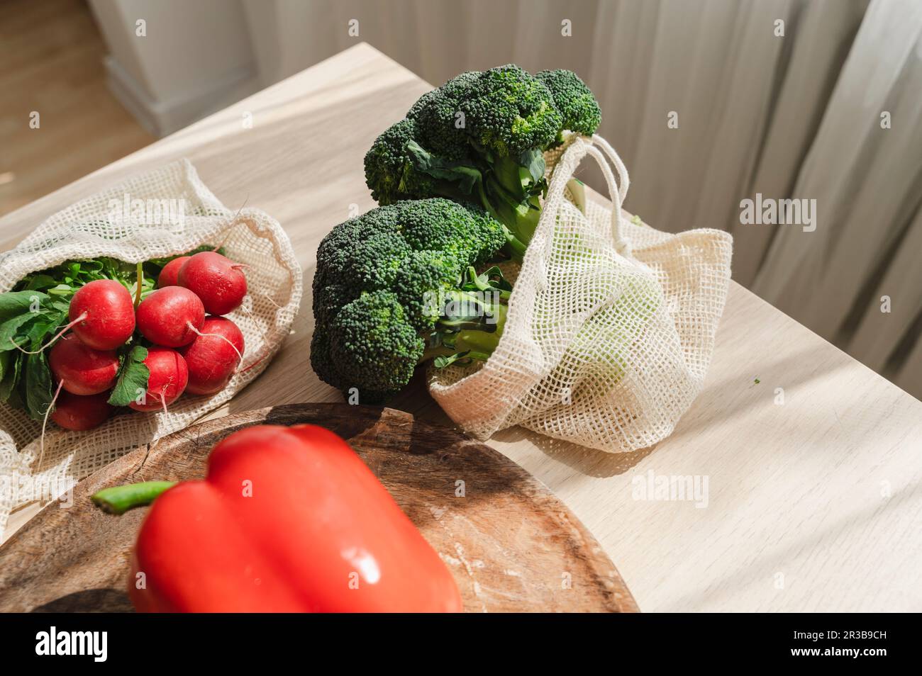 Fresh broccoli with radish and red bell pepper on table at home Stock Photo