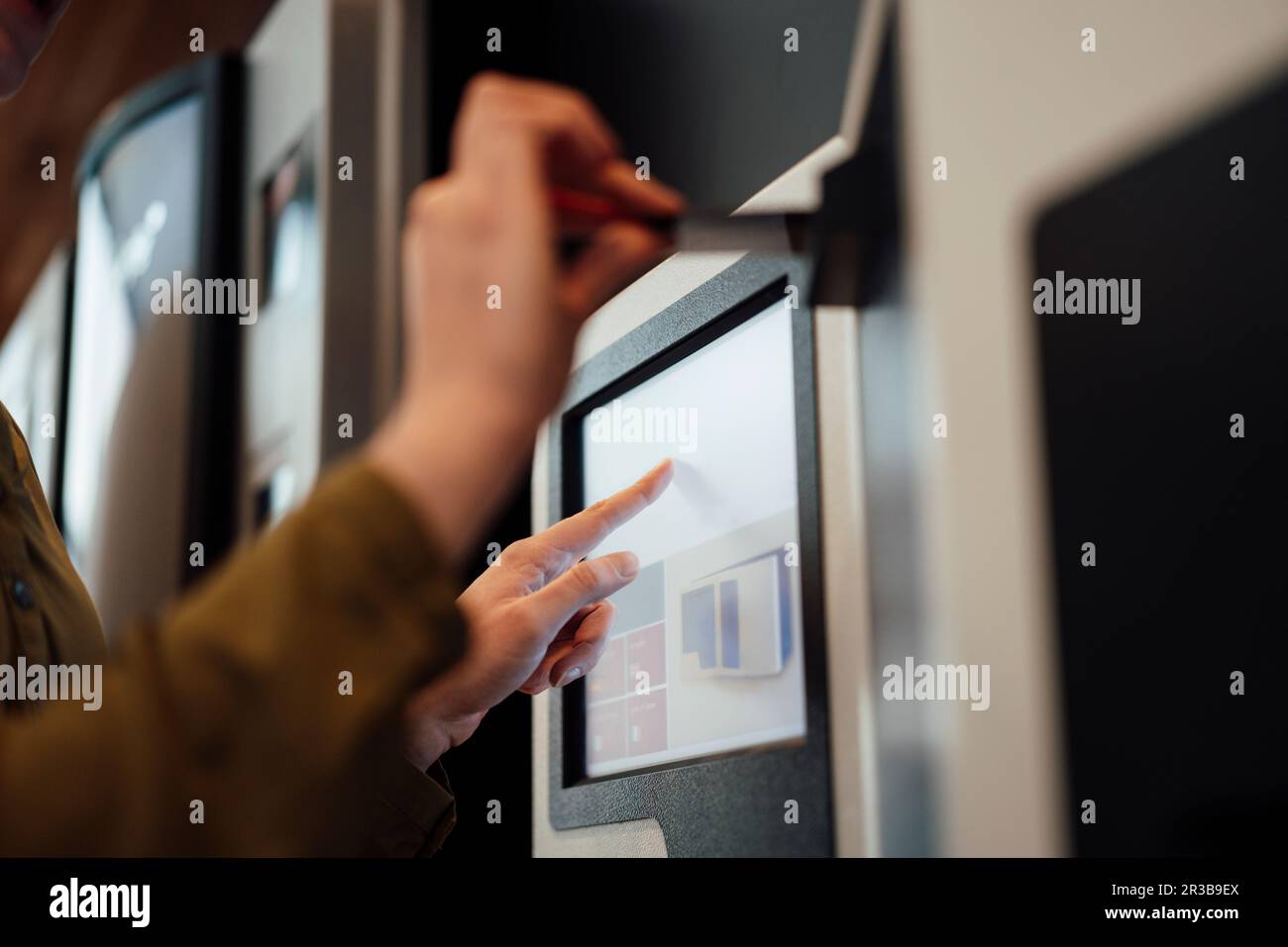 Woman touching screen of ATM machine Stock Photo