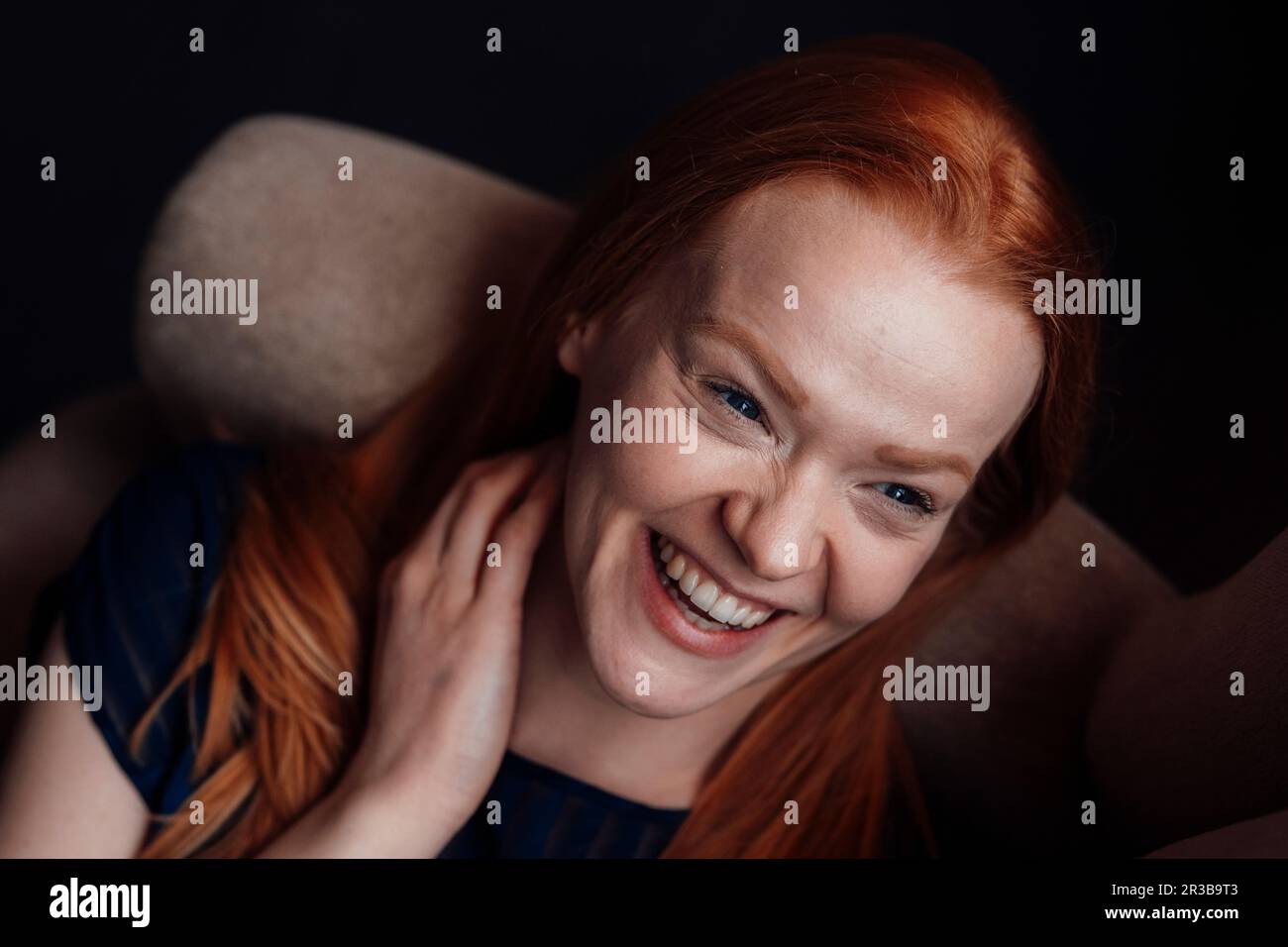 Happy woman lying down on sofa Stock Photo - Alamy