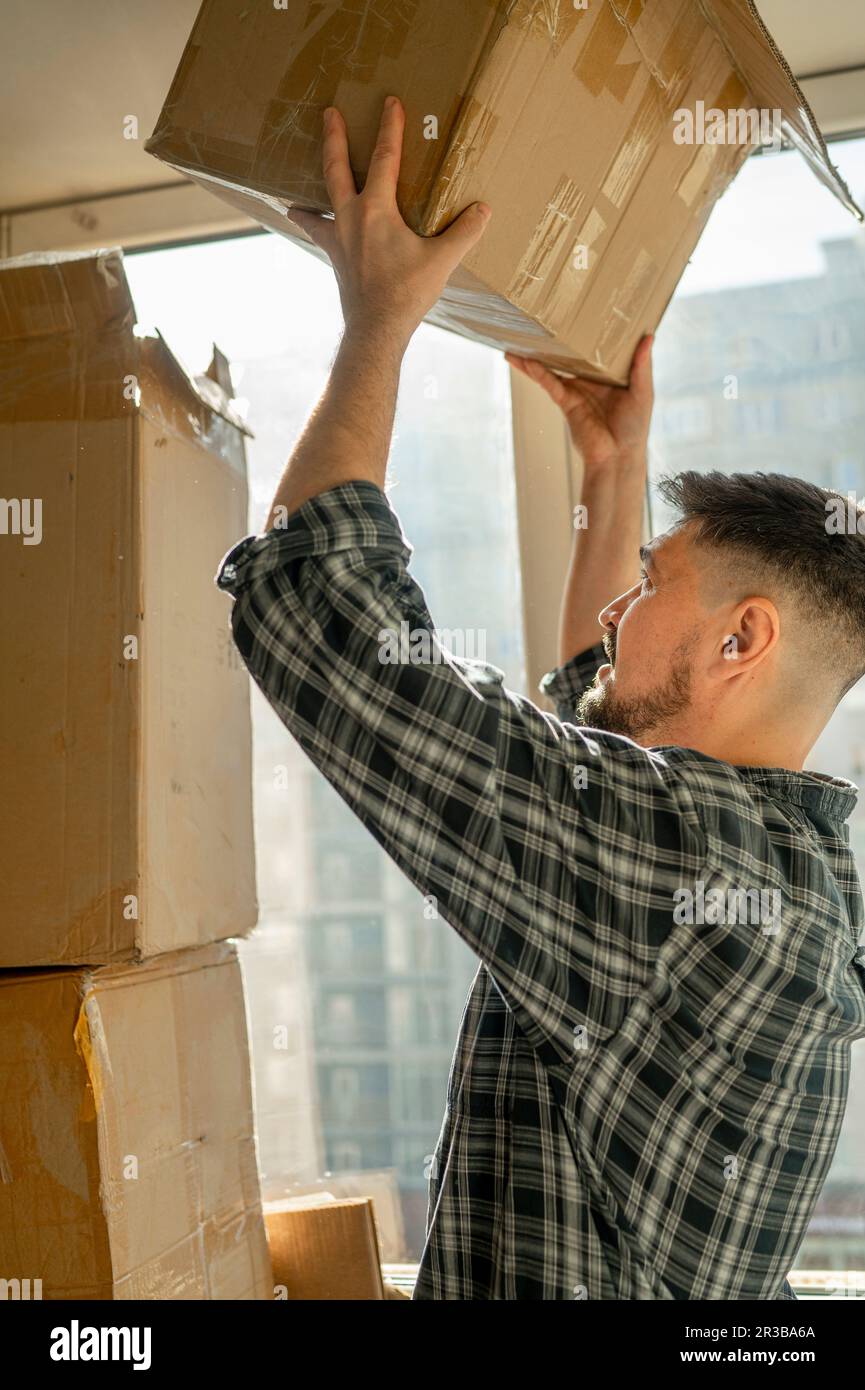 Man stacking boxes on each other at home Stock Photo Alamy