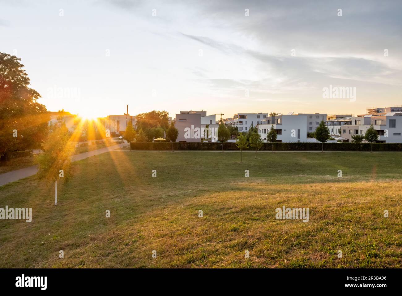 Grassy area front new modern suburban flats sunset hires stock