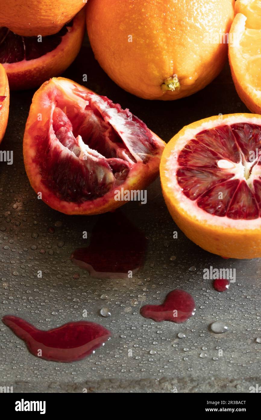 Oranges and blood oranges, partially juiced Stock Photo Alamy