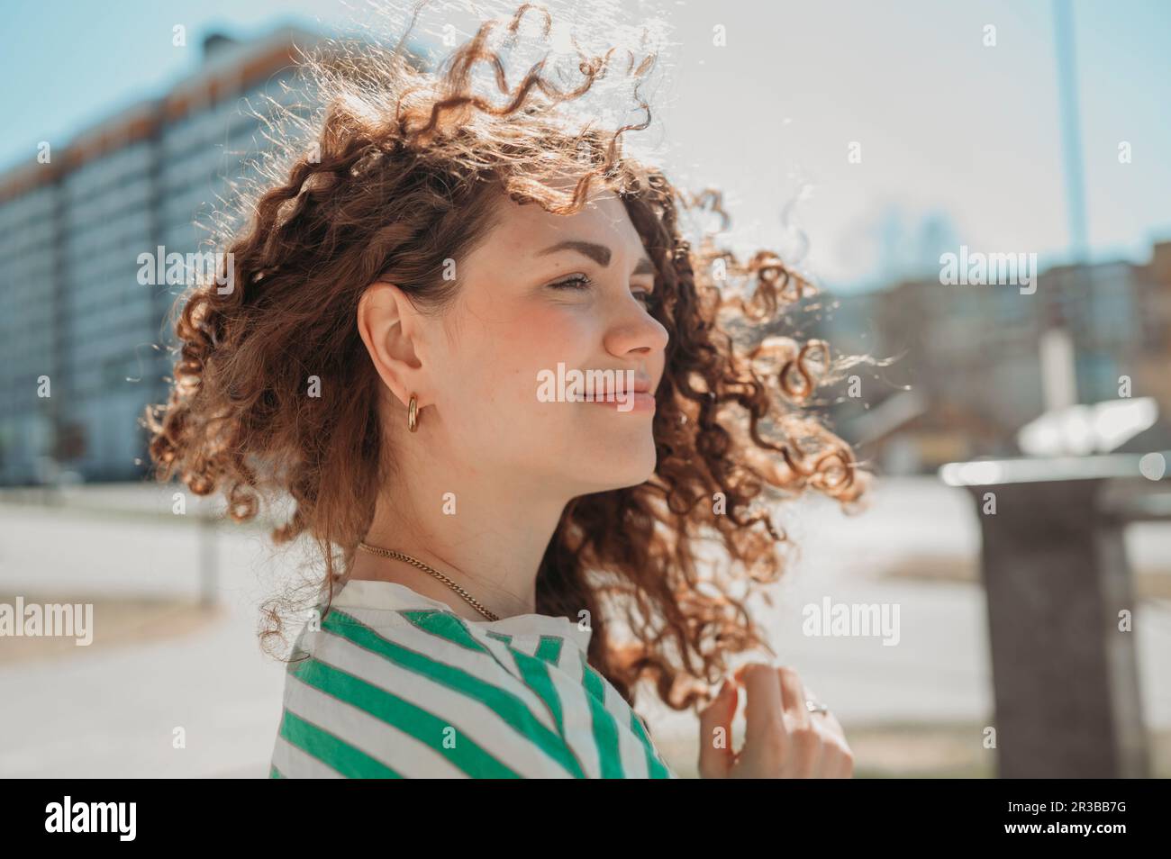 Smiling young woman with curly hair Stock Photo