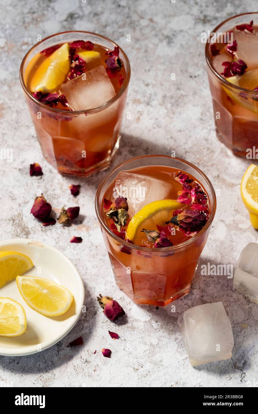 Lemonade made of rose syrup with lemon juice, ice cubes, rose petals and dried rose flowers
