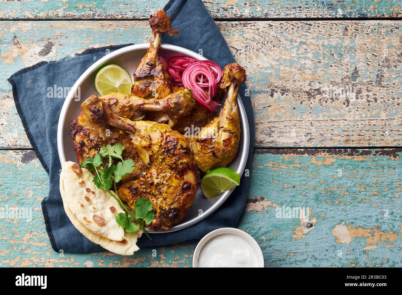 Tandoori chicken marinated in tikka served with rice naan, lime, plain