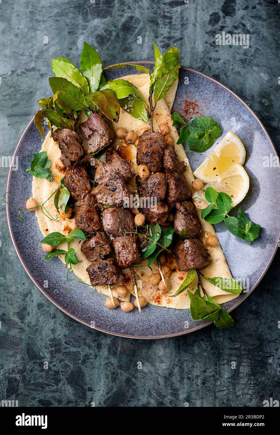 Lamb skewers with flatbread and chickpea salad Stock Photo