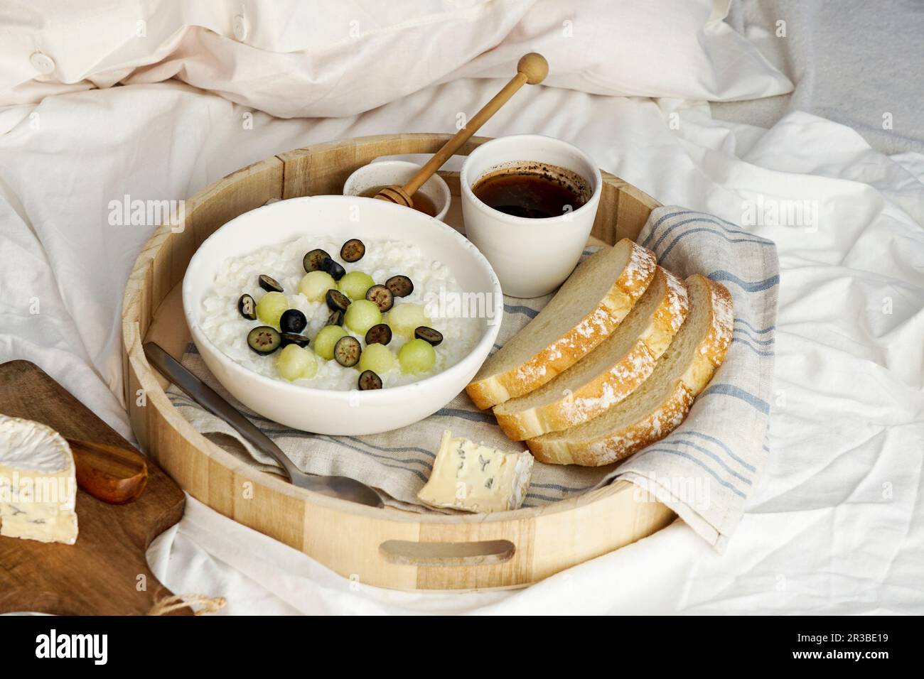 Breakfast in bed - rice porrige with honey and melon, blueberries Stock Photo