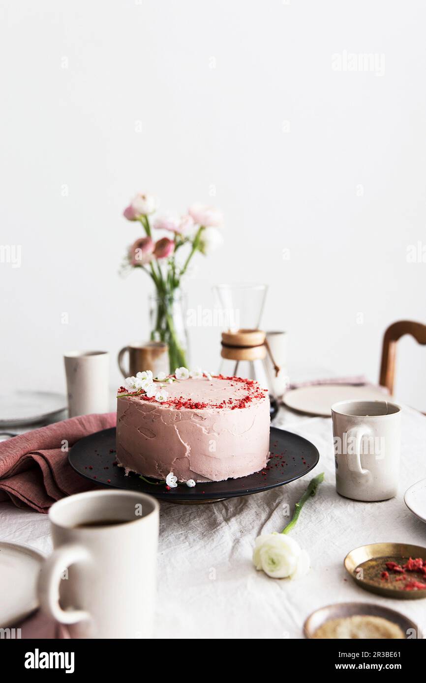 A strawberry cream cake on table laid for coffee Stock Photo