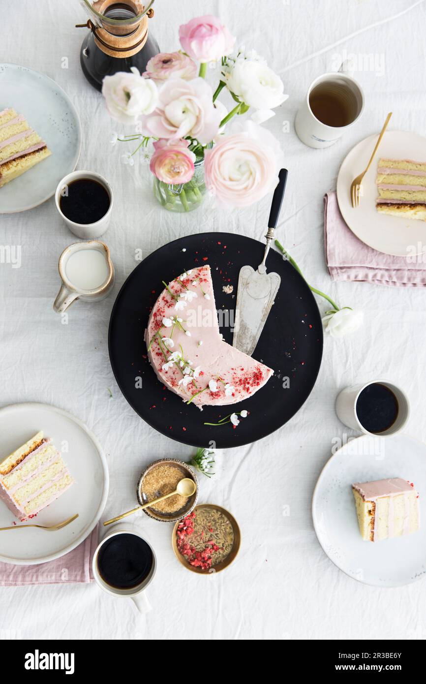 A strawberry cream cake on spring table laid for coffee Stock Photo