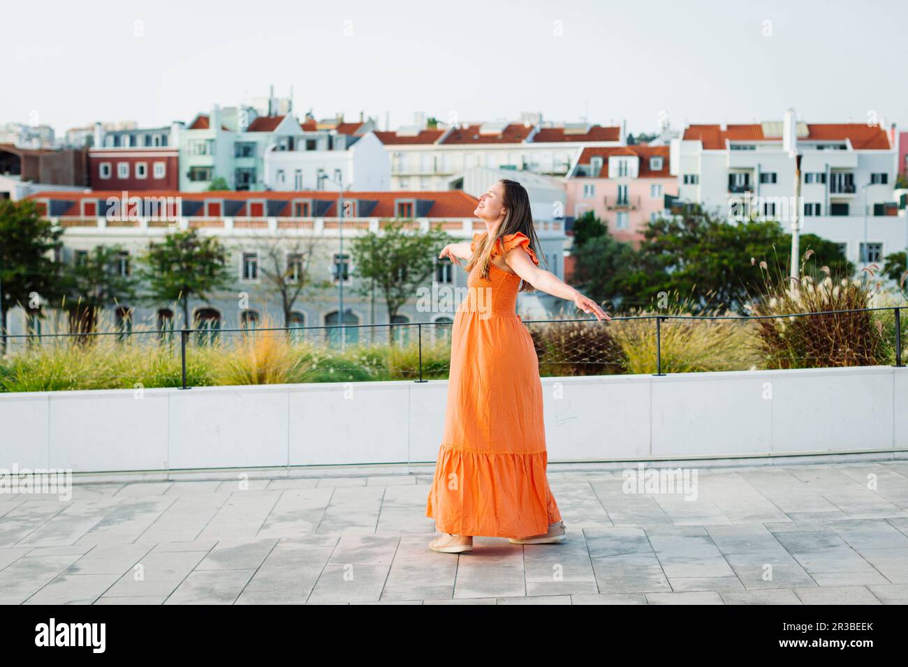 Woman in orange dress walking hi-res stock photography and images - Alamy