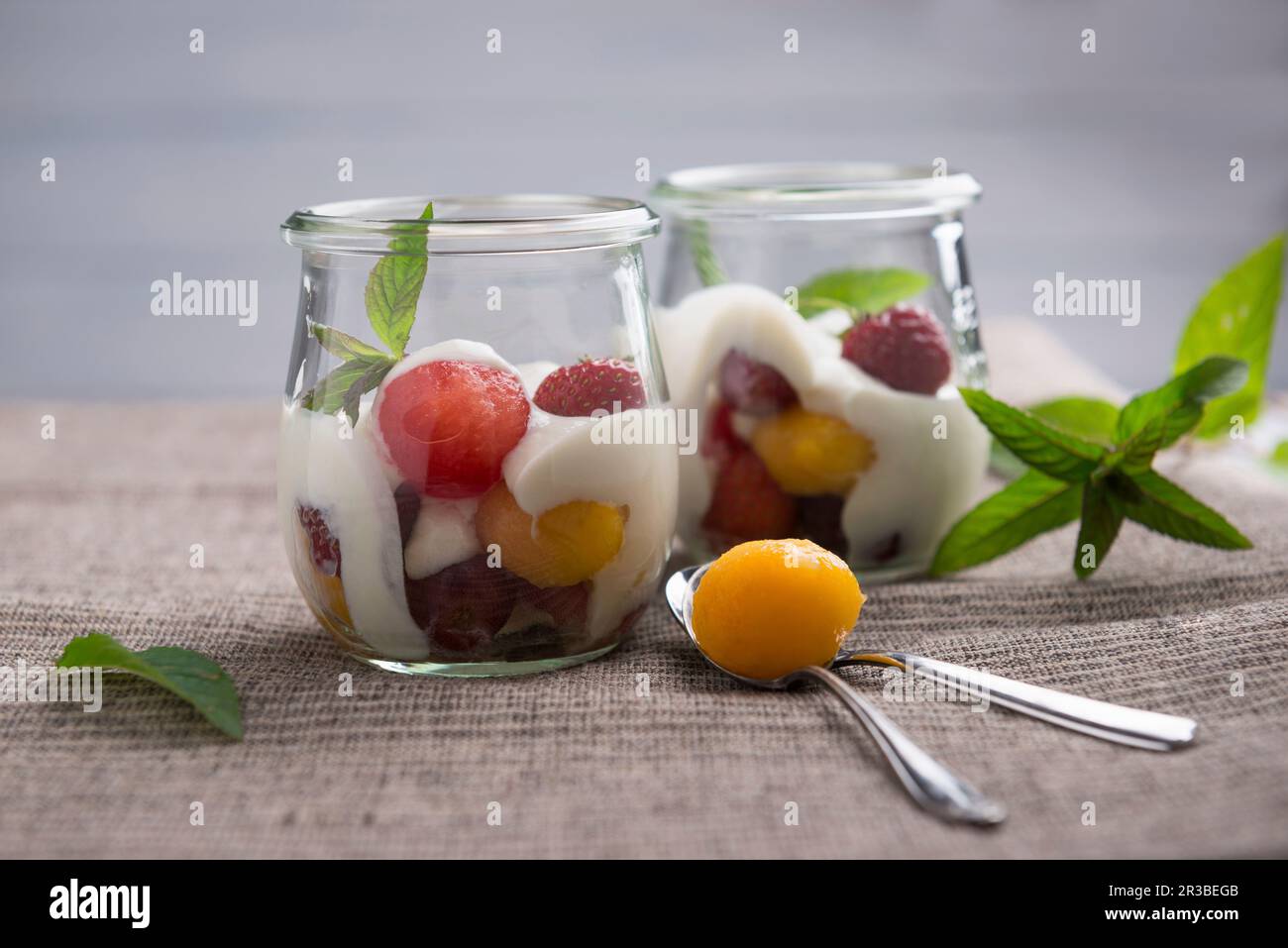 Soya yoghurt with melon and peach ball, strawberries and red grapes Stock Photo