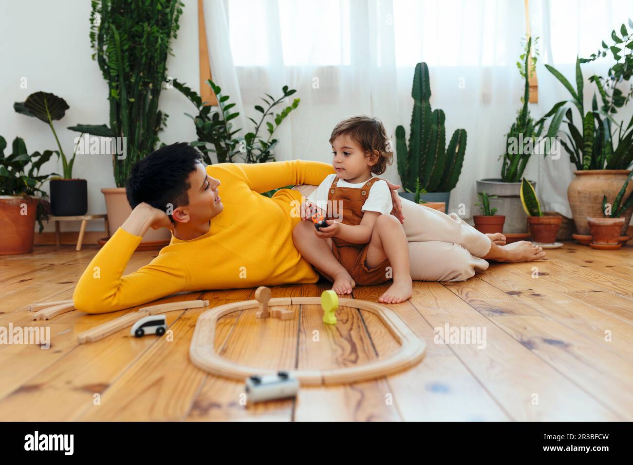 Mother lying down by son playing at home Stock Photo