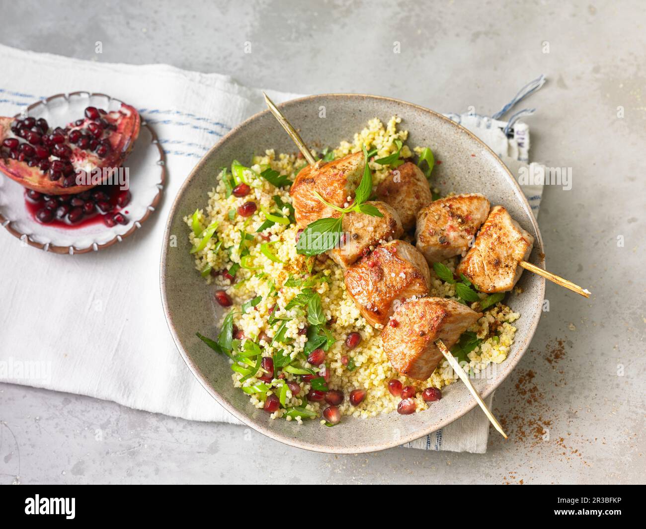 Oriental chicken kebab with couscous and pomegranate seeds Stock Photo