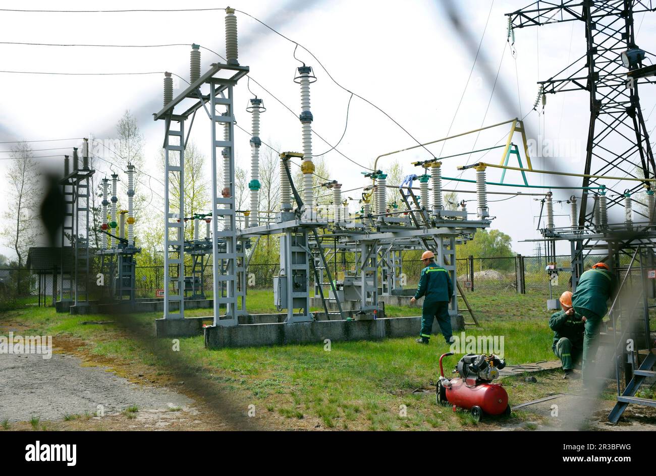 Workers fixing high-voltage line of an electric substation, shot ...