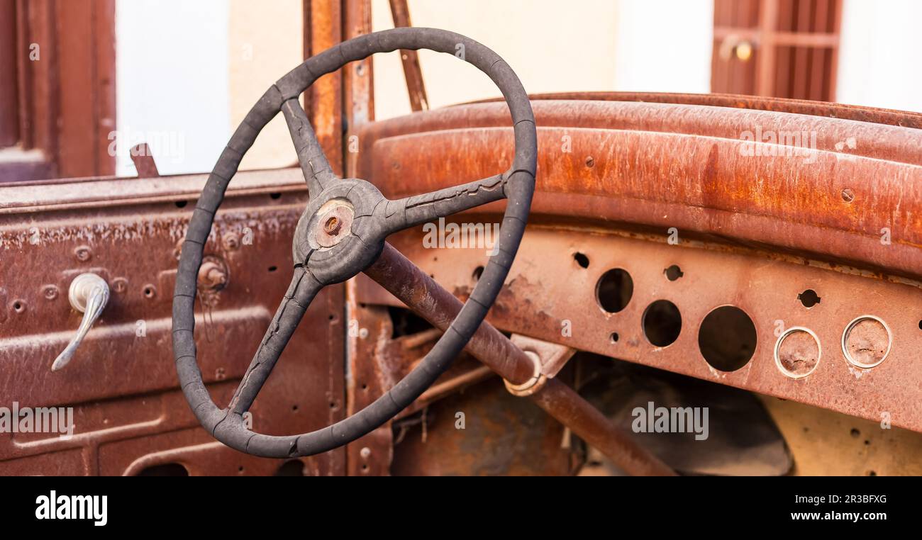 Old rusty motor car steering wheel in a scrap yard Stock Photo