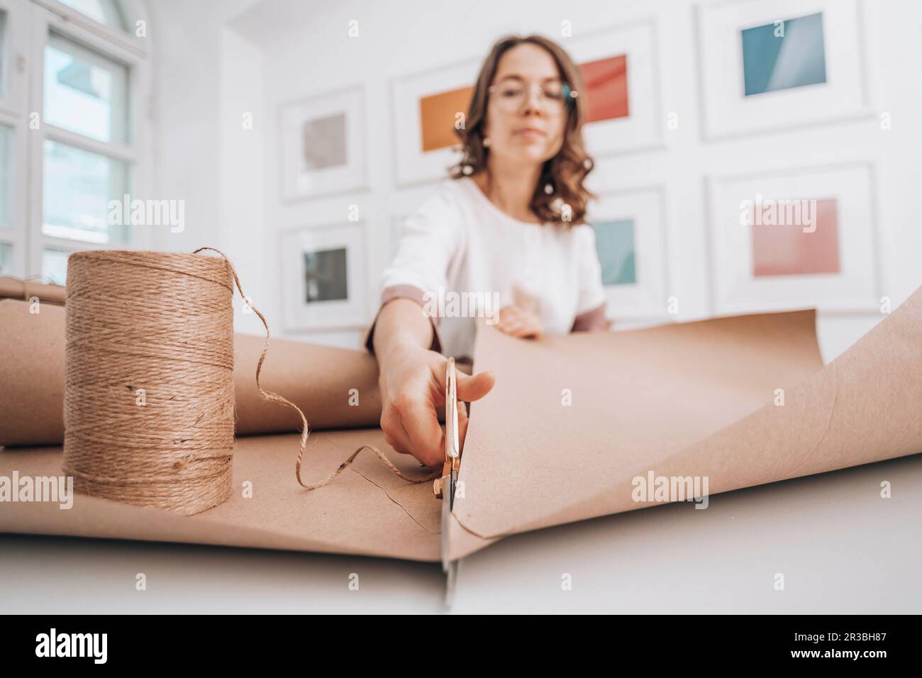 Fashion designer cutting wrapping paper by thread spool at